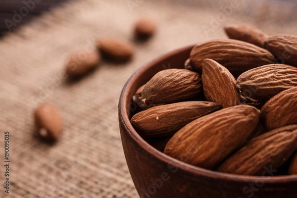 Fototapeta almond essential oil on a wooden background