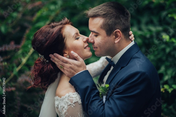 Fototapeta beautiful gorgeous bride and groom walking in sunny park and kis