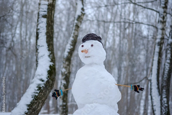 Fototapeta the funny snowman in the snowy forest