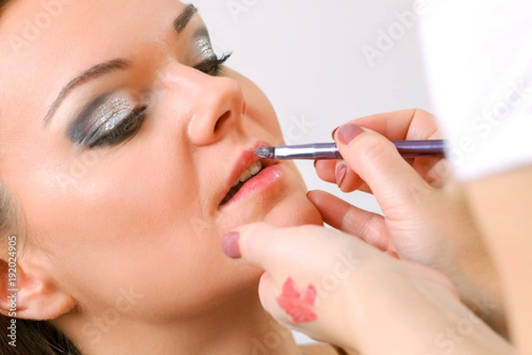 Fototapeta Professional Make-up artist doing glamour model makeup at work