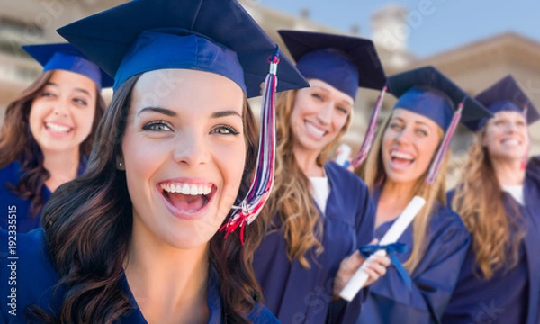 Fototapeta Happy Graduating Group of Girls in Cap and Gown Celebrating on Campus.