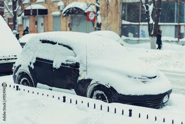 Obraz parked car stands along the road all in the snow