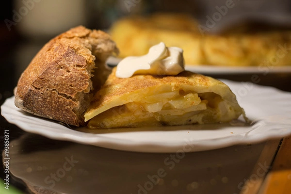 Fototapeta Piece of spanish omelette in a white plat  with bread and  mayonnaise