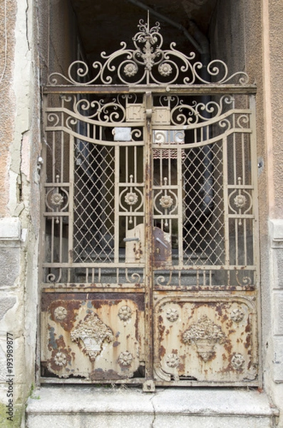 Fototapeta Old rusty wrought ironwork door closeup