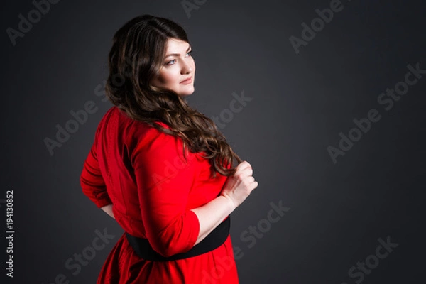 Fototapeta Plus size fashion model in red dress, fat woman on gray background, overweight female body