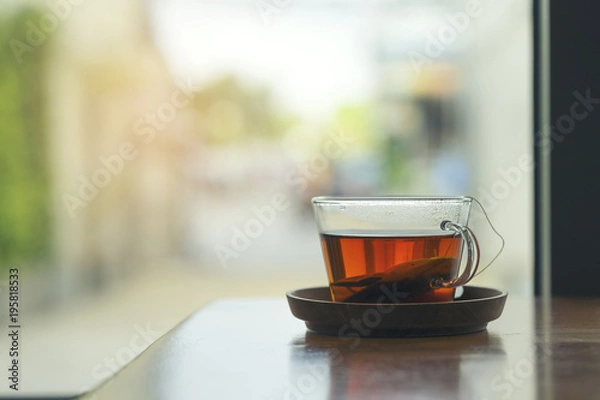 Fototapeta A cup of hot tea on wooden table for breakfast in the morning, coffee shop making hot tea with small wooden tray for customer's order