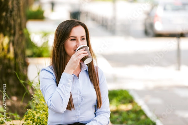 Fototapeta Beautiful businesswoman drinks coffee to go