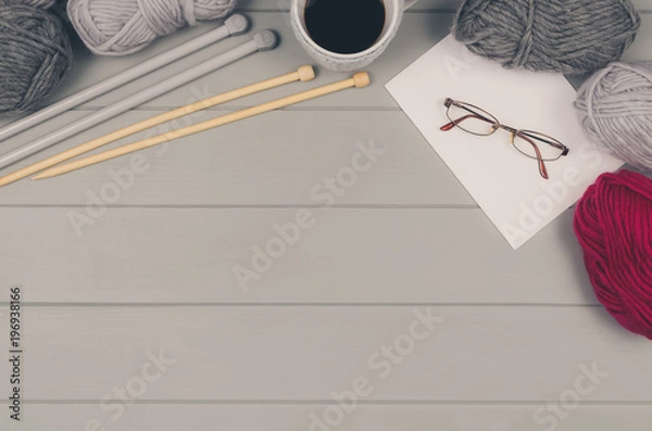 Obraz Knitting accessories assortment background with wool and needles on gray wooden table. Photograph taken from above top view. Frame composition with copy space around products.