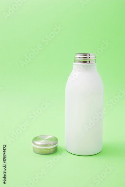 Fototapeta White thermo bottle on a green background