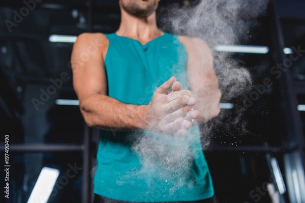 Fototapeta cropped view of sportsman with talcum powder in sports hall