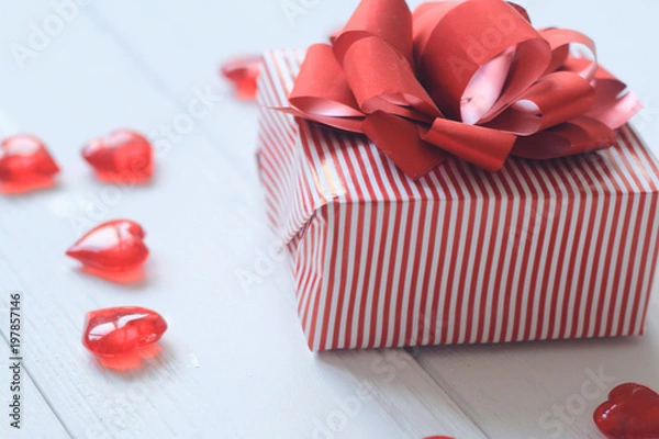 Fototapeta gift box with red bow and hearts on light background