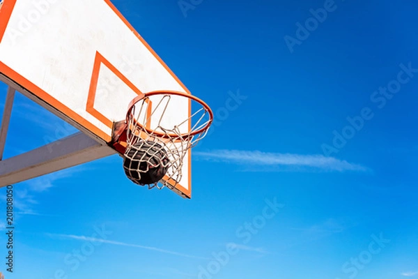 Fototapeta basketball close up, basketball bal in hoop at sunny day