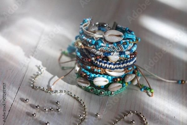 Fototapeta handmade bracelets with beads and cowrie shells from the threads