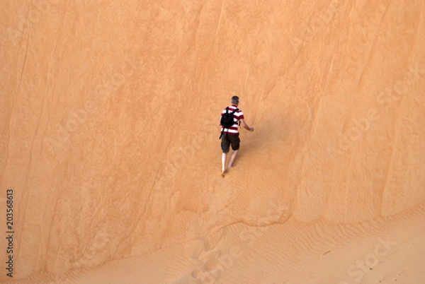 Fototapeta Walking on a sand dune