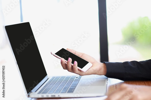 Obraz Marketing Analyst
woman is reading text message on mobile phone in network while is sitting with laptop computer