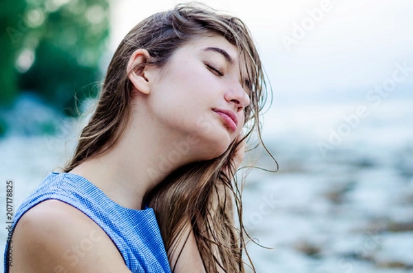 Fototapeta Portrait of a young beautiful girl on vacation. girl with long hair on the background of the sea.  happy girl on island in the ocean.
