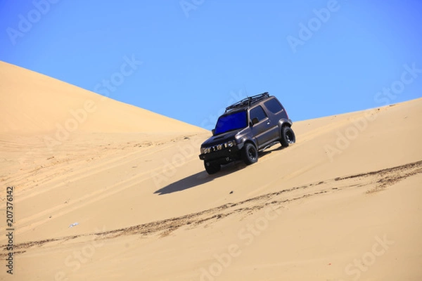 Fototapeta Off-road vehicle traveling in the desert