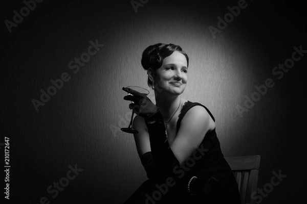 Fototapeta Dramatic portrait of a beautiful woman with glass of martini .