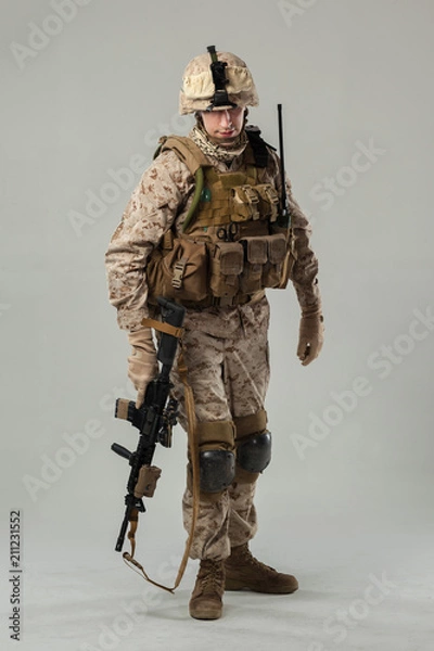 Fototapeta Soldier in camouflage holding rifle