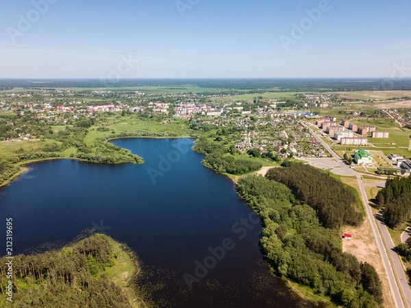 Fototapeta Beautiful aerial view of blue lake and green forest district in 