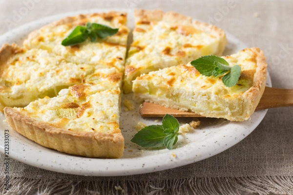 Fototapeta Pie with zucchini, cheese and mint on the table