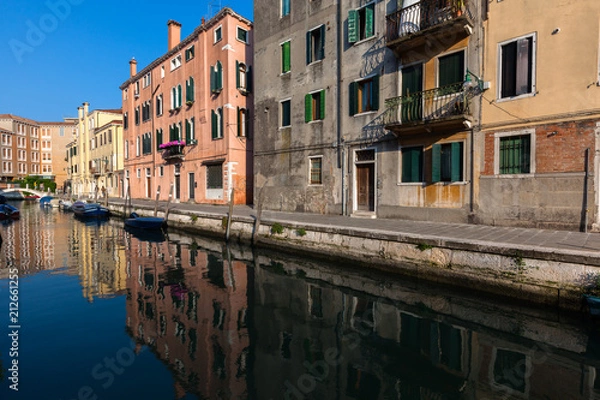 Fototapeta Colourful buildings reflect in a still canal, Venice, Italy