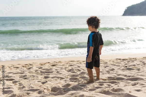 Fototapeta Kid wearing a swimming suit and looking to the sea