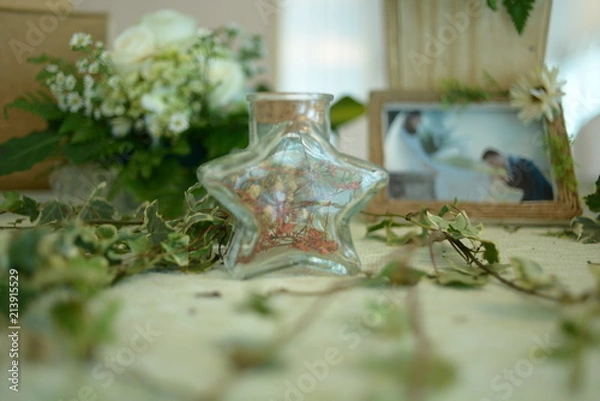 Fototapeta HO CHI MINH CITY, VIET NAM, MARCH, 2018: Original wedding floral decoration in the form of mini-vases and bouquets of flowers put in the table with beautiful mat, green style wedding, a modern wedding