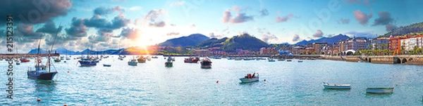 Fototapeta Paisaje de mar,pueblo y montañas. Barcos pescando y puesta de sol. Castrourdiales,Cantabria. España