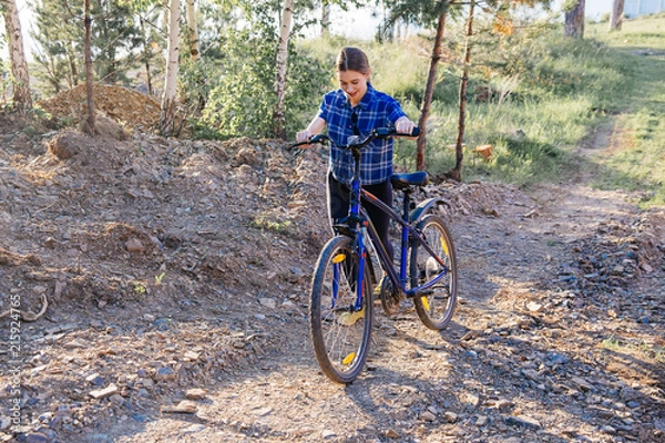 Fototapeta Young woman riding a bike