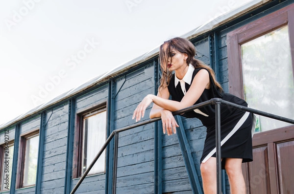 Fototapeta Girl posing on railway in black dress