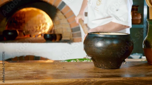 Fototapeta Traditional Russian stove with cooking food on wood in crock