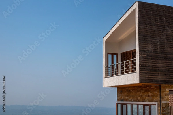 Fototapeta Side view of one modern penthouse apartmen with large balcony. Blue sky and horizon in the background.