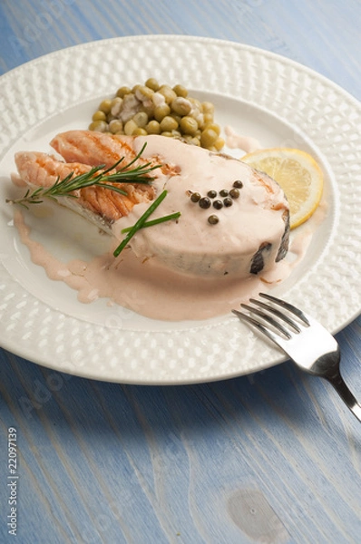 Fototapeta salmon with cream sauce on dish and fork