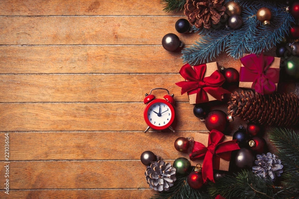 Fototapeta alarm clock with Christmas decoration around on wooden table. Above view in old color style