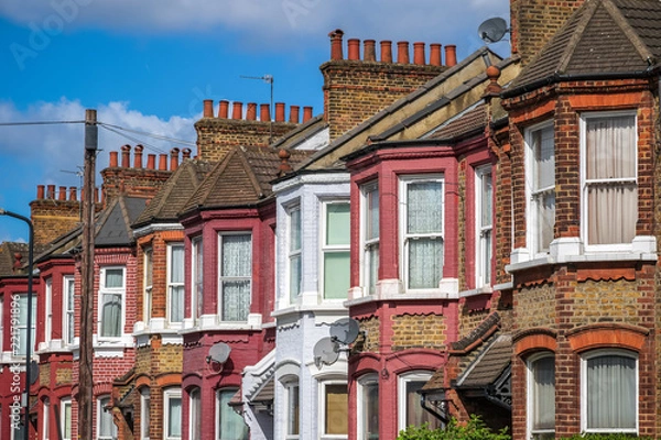 Fototapeta A row of typical British terraced houses in London with a telephone pole