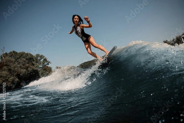 Fototapeta Dziewczyna jedzie na wakeboardzie nad jeziorem