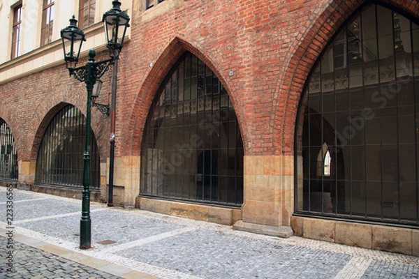 Fototapeta old style big arch windows in brick wall, street light