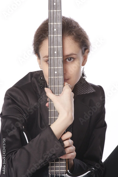 Fototapeta Young woman posing in studio with a black electric bass guitar