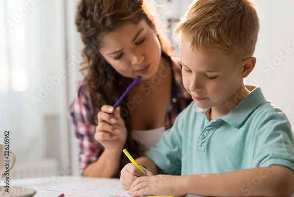 Fototapeta Little boy sketching with his mother at home