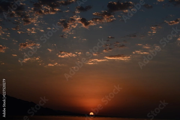 Fototapeta Beautiful blazing sunset landscape at Caspian Sea and orange sky above.