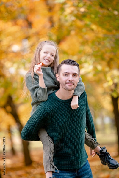 Fototapeta Family of dad and kid on beautiful autumn day in the park