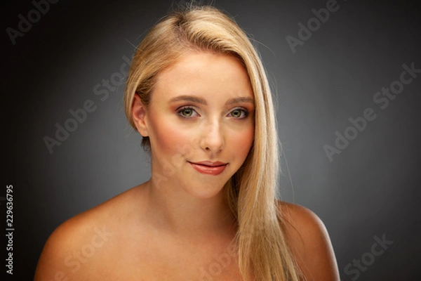 Fototapeta Beautiful young woman with green eyes over dark gray background