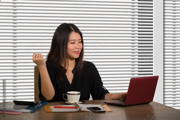 Fototapeta young beautiful and successful Asian Korean business woman working confident at modern office computer desk in female businesswoman success