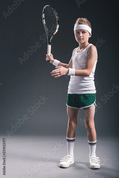 Fototapeta focused boy in sportswear with tennis racket on dark background