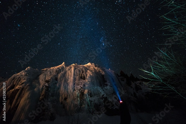 Fototapeta A woman admires the Milky Way above the frozen Colorado Rocky Mountains