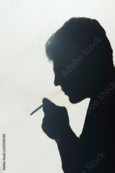 Fototapeta shadow of smoking man, young man smoking a cigarette, concept abstract background