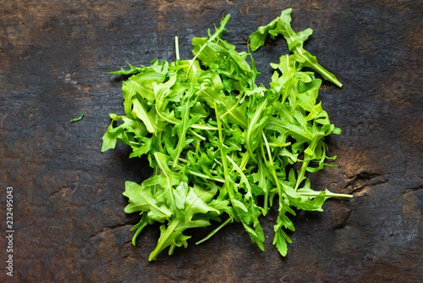 Fototapeta Fresh arugula salad,washed baby rocket on a wooden chopping board, breakfast healthy food.