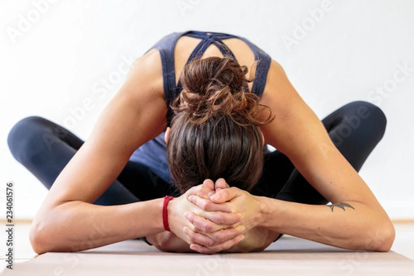 Fototapeta young woman practicing yoga on the floor