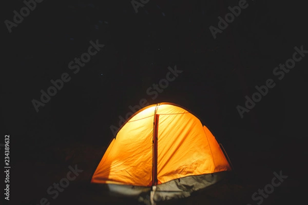 Fototapeta View of an orange tent under the night sky with a campfire in american campground, Yosemite National Park, California, United States